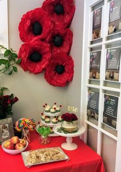 a red table topped with cakes and desserts