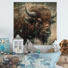 a room with a bed, pillows and pictures on the wall above it that has an image of a bison