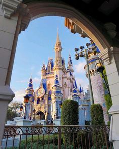 the entrance to disneyland's castle is seen through an archway