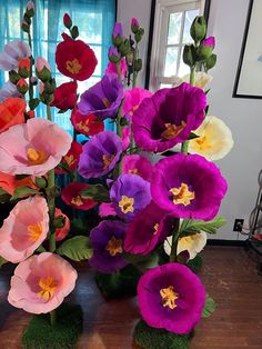 there are many different colored flowers in the vases on the table, one is pink and one is purple