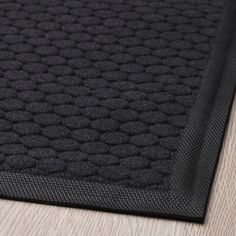 a close up view of a black rug on the floor