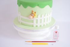 a green cake with a horse on it and some crayons next to it