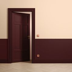 an open door in a room with red walls and parquet flooring on the side