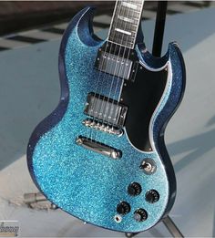 a blue electric guitar sitting on top of a stand