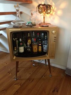 an old fashioned television with liquor bottles on it