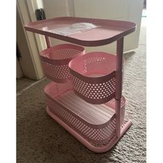 a pink shelf with three baskets on it