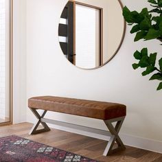 a bench with a mirror on the wall behind it