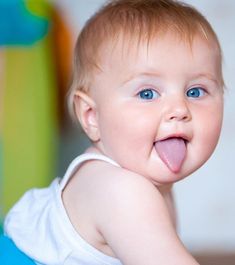 a close up of a baby making a funny face