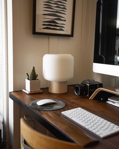 a wooden desk with a computer monitor, keyboard and mouse on it in front of a window