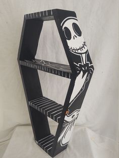 a wooden shelf with a skeleton painted on the front and bottom part, holding shelves