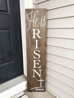 a wooden sign that says he is risen written on the side of a house door