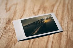 an open photo album sitting on top of a wooden table