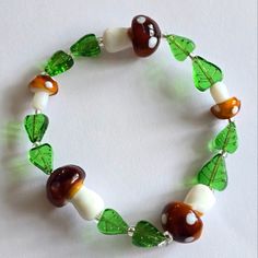 I Handmade This Bracelet Using Glass Mushroom Beads And Glass Leaf Beads, Strung On Strong And Stretchy Elastic Cord. Colors Are : Brown, White, Green, And Clear. Fits A Medium To Larger Wrist Best. See Photo Next To Quarter For Size Reference Ships Fast! Buffh8388jw3b5l2 Beaded Forest Forestcore Cottage Cottagecore Fungus Fungi Mycology Women's Hand Crafted Aminata Spotted Spots Polka Dot Jewelry Goblin Core Accessories, Fairy Core Bracelets, Goblincore Trinkets, Goblincore Accessories, Goblincore Crafts, Cottagecore Bracelet, Mushroom Bracelet, Cottagecore Diy, Mushroom Beads