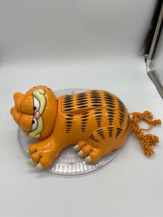 an orange plastic toy laying on top of a glass plate