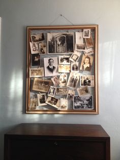 a wooden dresser sitting next to a wall covered in pictures and framed with an old fashioned frame