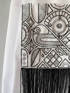 a white shirt with black and white designs on it