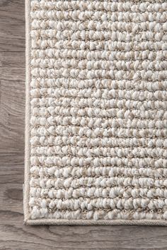 a white rug on top of a wooden floor