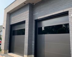 two garage doors are open in front of a brick building