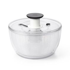 a food processor on a white background with a black lid and plastic strainer in the middle