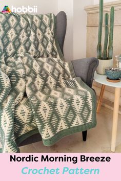 a green and white blanket sitting on top of a chair next to a potted plant