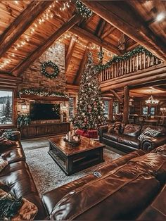 a living room filled with furniture and a christmas tree in the middle of the room