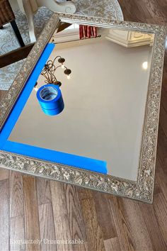 a mirror with blue tape on it sitting on the floor