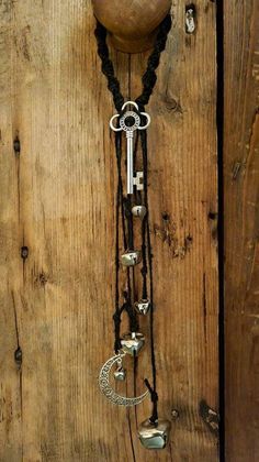 a necklace with an old key hanging from it's side on a wooden wall