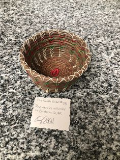 a small basket sitting on top of a counter next to a sign that says,