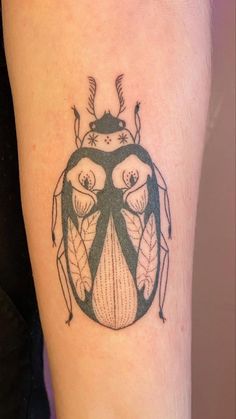 a black and white beetle tattoo on the leg