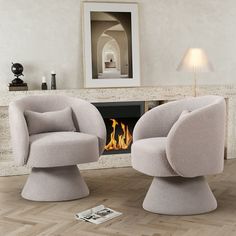 two chairs sitting next to each other in front of a fireplace