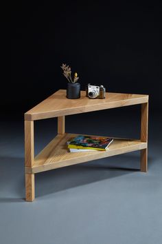 a wooden table with a magazine on it and a camera sitting on top of it