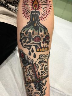 a person with a tattoo on their leg that has a skull and fireworks in the background