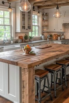 a large kitchen island with stools next to it and lights hanging from the ceiling