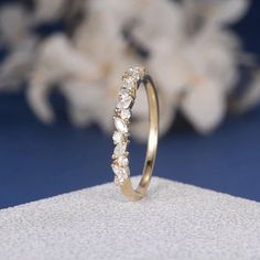 a diamond ring sitting on top of a piece of white paper next to some flowers