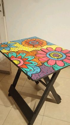 a multicolored table sitting on top of a tiled floor next to a door