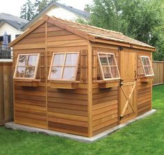 a small wooden shed with windows on the side