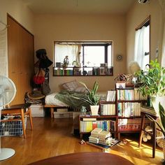 a living room filled with lots of furniture and books on top of a hard wood floor