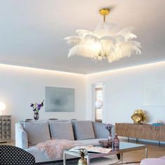 a living room filled with furniture and a chandelier hanging from the ceiling above it