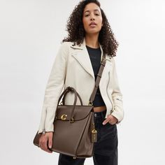 Our Broome has all the effortless cool of its namesake Soho street. The spacious foldover silhouette is crafted of luxe refined leather with a high shine finish and secures with our pushlock “C” closure. Featuring pockets inside and out for easy organization and room for a 16” laptop carry it by hand or use the detachable strap to wear it crossbody. | Coach Broome Carryall Bag 36 - Women's - Brass/dark Stone Soho Street, Crossbody Coach, Easy Organization, Work Bag, Carry All Bag, Tote Handbags, Inside Pocket, Carry On, Women Handbags