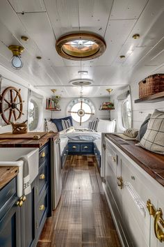 the interior of a boat with wood floors and white walls, along with blue cabinets