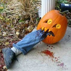 a person laying on the ground next to a pumpkin