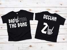 two black shirts with white letters on them, one says bad to the bone 2