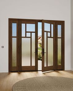 an open door in a room with wood flooring and glass doors leading to the outside