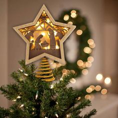 a christmas tree with a star decoration hanging from it's side and lights on the top