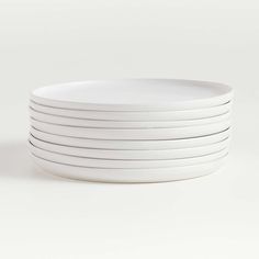 white plates stacked on top of each other in front of a white background with no one around them