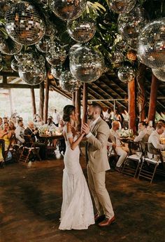 a bride and groom dancing under disco balls