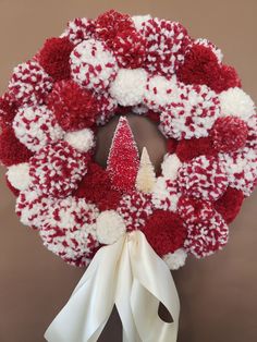 a wreath with red and white pom - poms