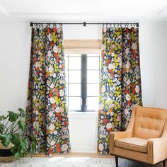 a chair sitting in front of a window next to a potted plant