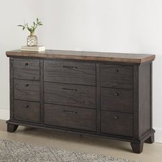 a large wooden dresser sitting on top of a hard wood floor next to a white wall