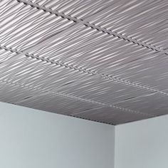 a room with white walls and a ceiling that has metal lines on the ceiling above it